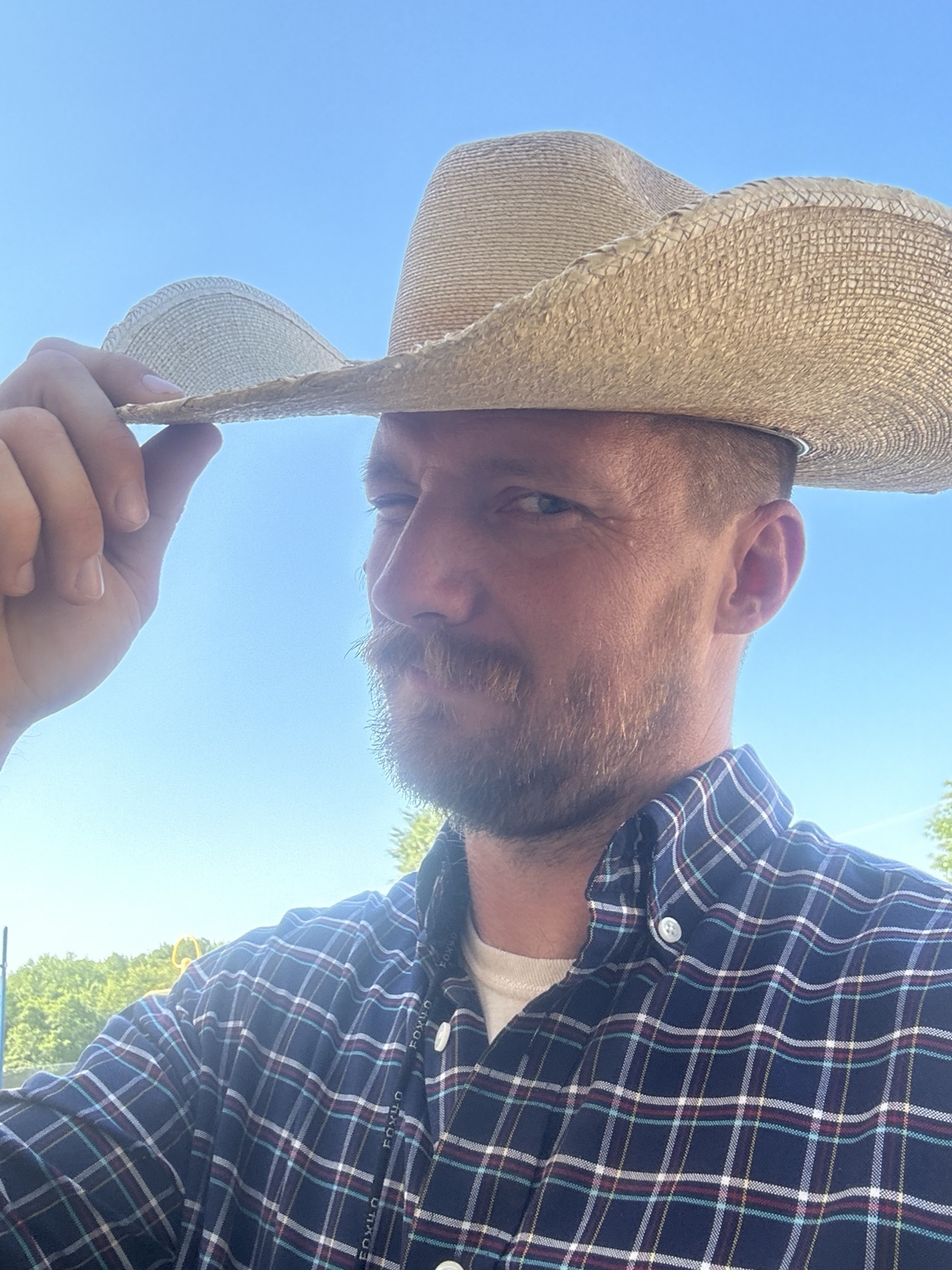 Russel Ramsey wearing a cowboy hat outdoors